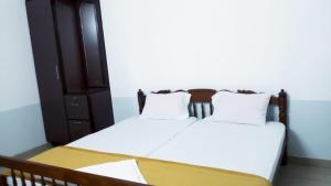 1 dormitorio con 2 camas con sábanas blancas y armario en Jinan palace out house en Nedumbassery