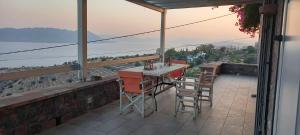 a table and chairs on a balcony with a view at Holiday Home in Sfendouri, Aegina in Sfendoúrion
