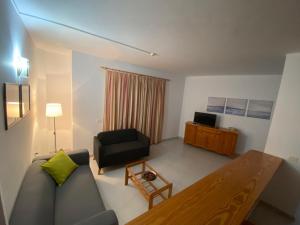 a living room with a couch and a table at Apartamentos Martell in Playa de Santiago