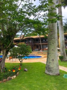 un complejo con una palmera y una piscina en Apart hotel a 150m da praia de Geribá, en Búzios