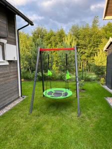 a swing set on the grass in a yard at Domkoland in Dziwnówek