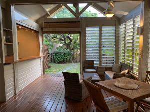 a screened in porch with a table and chairs at Bungalow Sable de Corail à 2 pas de la plage et lagon in La Saline les Bains +20 photos