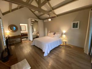 a bedroom with a white bed and a mirror at Bungalow Sable de Corail à 2 pas de la plage et lagon in La Saline les Bains