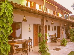 un patio al aire libre con mesa de madera y sillas en La Tana del Tano Guest House, en Búzios