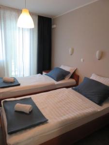 a hotel room with two beds with a towel on them at Guesthouse ob Sotočju Budič in Brežice