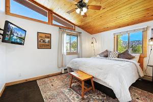 1 dormitorio con 1 cama y ventilador de techo en Misty Mountain Lodge, en Estes Park