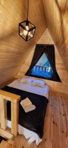 a bed in a wooden room with a window at KAZBEGI COMPASS in Stepantsminda