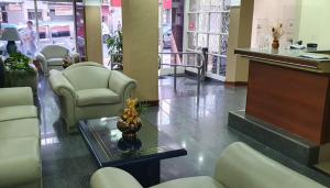 uma sala de espera com cadeiras e uma mesa num hospital em Hotel AATRAC Buenos Aires em Buenos Aires
