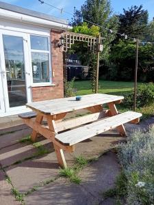 a wooden picnic table in front of a house at Kara Mia in Boston