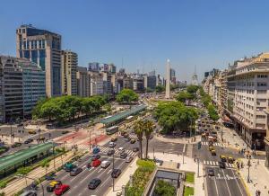 eine belebte Stadtstraße mit Verkehr in einer Stadt in der Unterkunft Hotel AATRAC Buenos Aires in Buenos Aires