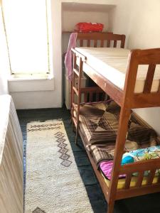 a room with two bunk beds and a rug at Hostel Ka Doma in Cetinje
