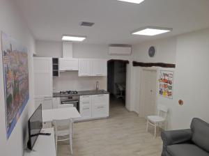 cocina con armarios blancos, mesa y sillas en Apartments Villas Cagliari en Cagliari