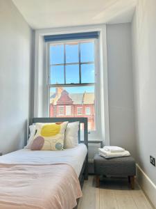 a bedroom with a bed and a large window at 2 Bedroom Apartment in South Hampstead in London