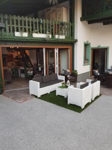 a living room with white couches and a patio at Mama's House in Cerklje na Gorenjskem