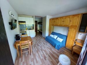 een woonkamer met een blauw bed en een tafel bij Appartement vacances à la montagne - Massif des Brasses in Bogève