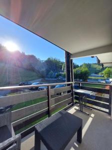 a balcony with a bench and a view of a highway at Appartement vacances à la montagne - Massif des Brasses in Bogève
