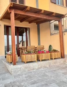 un pergolato in legno con due sedie e fiori su un patio di GIOIA'S HOUSE a Custonaci