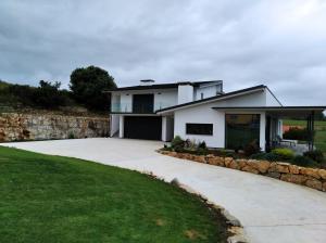 ein weißes Haus mit einer Steinmauer und einer Auffahrt in der Unterkunft Buenavista in Villapresente