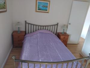 a bedroom with a purple bed with two night stands at Haven Apartments in Whitehaven