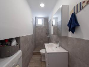 bagno con lavandino bianco e servizi igienici di Up the stairs renovated apartment with sea view a Poros