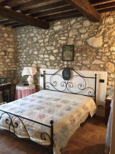 a bedroom with a bed in a stone wall at La Casetta al Roccone in Semproniano
