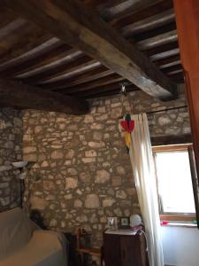 a bedroom with a stone wall and a window at La Casetta al Roccone in Semproniano +7 photos