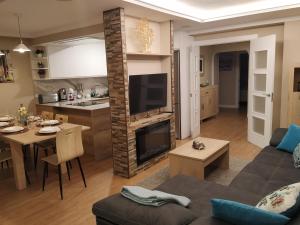 uma sala de estar e cozinha com um sofá e uma mesa em EL CAPRICHO - LUJO Y CONFORT EN EL CENTRO con PARKING INCLUIDO em Gijón