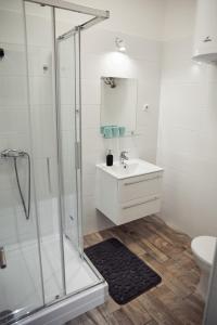 baño blanco con ducha y lavamanos en Beautiful View Duna Apartment en Budapest