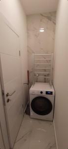 a washing machine in a small room with a door at Apartment Major in Belgrade