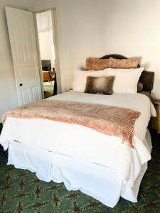 a bedroom with a large white bed with pillows at Bon Maison Guest House in New Orleans