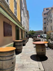 a row of wine barrels on a sidewalk next to a building at Ajaccio : appartement centre historique in Ajaccio