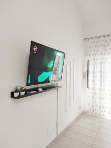 una TV a schermo piatto seduta sopra un muro bianco di Sweet Home a Termoli