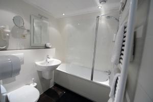 a bathroom with a shower and a toilet and a sink at Hotel Het Wapen van Drenthe in Roden +86 photos
