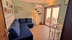 a living room with a blue couch and a balcony at Varandas do Mar in Arcozelo