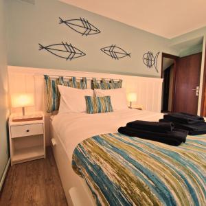 a bedroom with a bed with fish on the wall at Varandas do Mar in Arcozelo