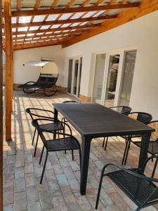 czarny stół i krzesła na patio w obiekcie Família Apartman Cserkeszőlő w mieście Cserkeszőlő