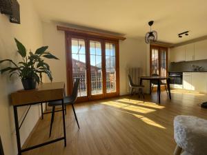 sala de estar con mesa y comedor en Appartement 53m2 rénové dans un chalet au coeur de Charmey avec vue sur les montagnes en Charmey