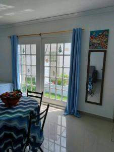 a dining room with a table and blue curtains at Holiday Loft Suite Apartamento in San Andrés