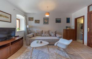 a living room with a couch and a tv at Apartments Franovic in Perast