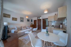 ein Wohnzimmer mit einem Sofa, einem Tisch und Stühlen in der Unterkunft Apartments Franovic in Perast