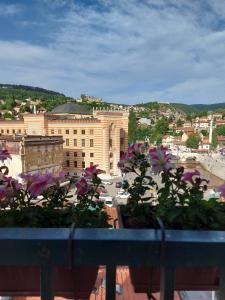 un balcón con flores y vistas a la ciudad en Intensa Emozione Sarajevo en Sarajevo