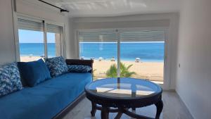 ein Wohnzimmer mit einem blauen Sofa und Strandblick in der Unterkunft Al amine plage in Fnideq