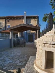eine Terrasse mit einem Steinkamin vor einem Haus in der Unterkunft Kuća za odmor Lazarić in Marčana