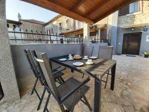 ein Holztisch und Stühle auf einer Terrasse in der Unterkunft Kuća za odmor Lazarić in Marčana