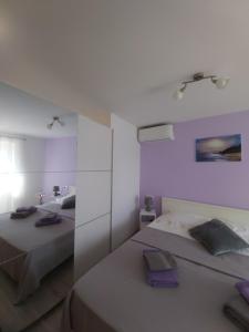 ein Schlafzimmer mit zwei Betten und einem Spiegel in der Unterkunft Kuća za odmor Lazarić in Marčana