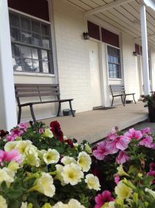 a bench in front of a building with flowers on it at Colonial Lodge Motor Inn in Yass