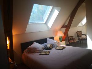 a bedroom with a bed with two pillows and a window at La Longère du Val in Tauxigny
