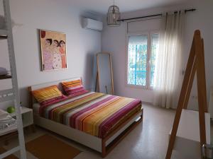 Habitación pequeña con cama y ventana en Superbe étage de villa vue sur mer en Nabeul