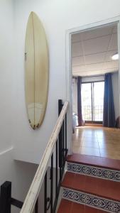 a surfboard hanging on a wall in a hallway at Villaparadisi in Benicàssim