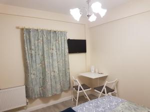 um quarto com uma cama, uma secretária e uma cortina. em Grant Rooms em Derry